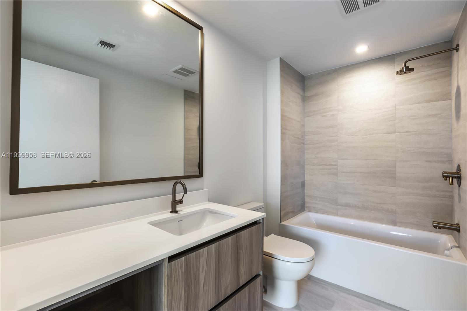 77 Southeast 5th Street, Unit 2905 Miami, FL 33131 - Photo 27 of 27 a bathroom with a sink a toilet and shower