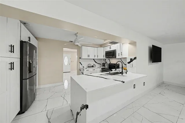 a kitchen with stainless steel appliances a refrigerator sink and microwave