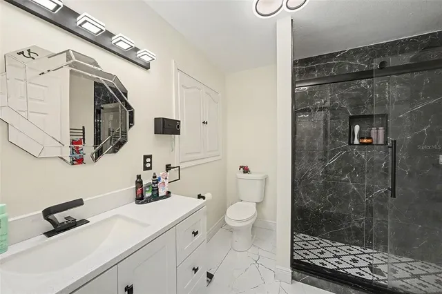 a bathroom with a sink a toilet and shower