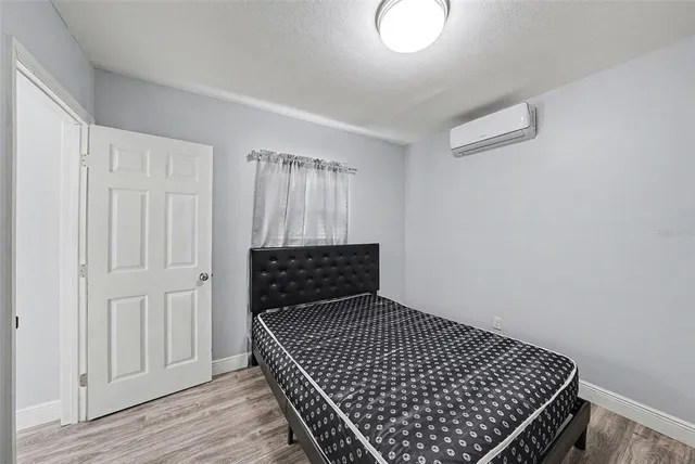 a bedroom with a bed and wooden floor