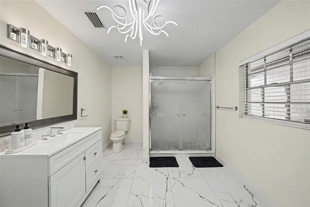 a bathroom with a sink a toilet and shower