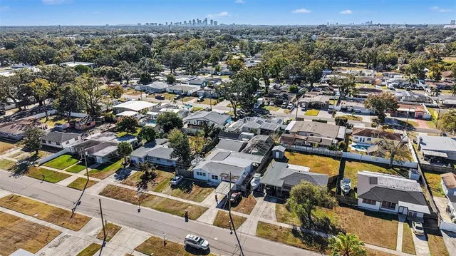 an aerial view of a city with lots of residential buildings and mountain view in back