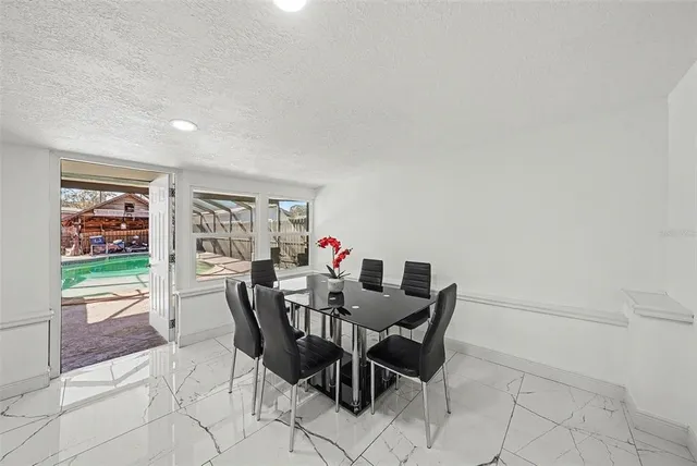 a view of a dining room with furniture and a floor to ceiling window
