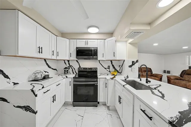 a kitchen with stainless steel appliances granite countertop a sink stove and refrigerator
