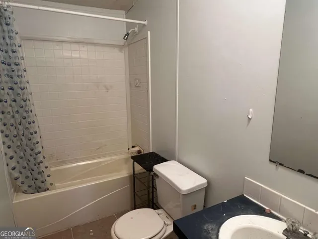 a white toilet and tub sitting next to a bathroom sink