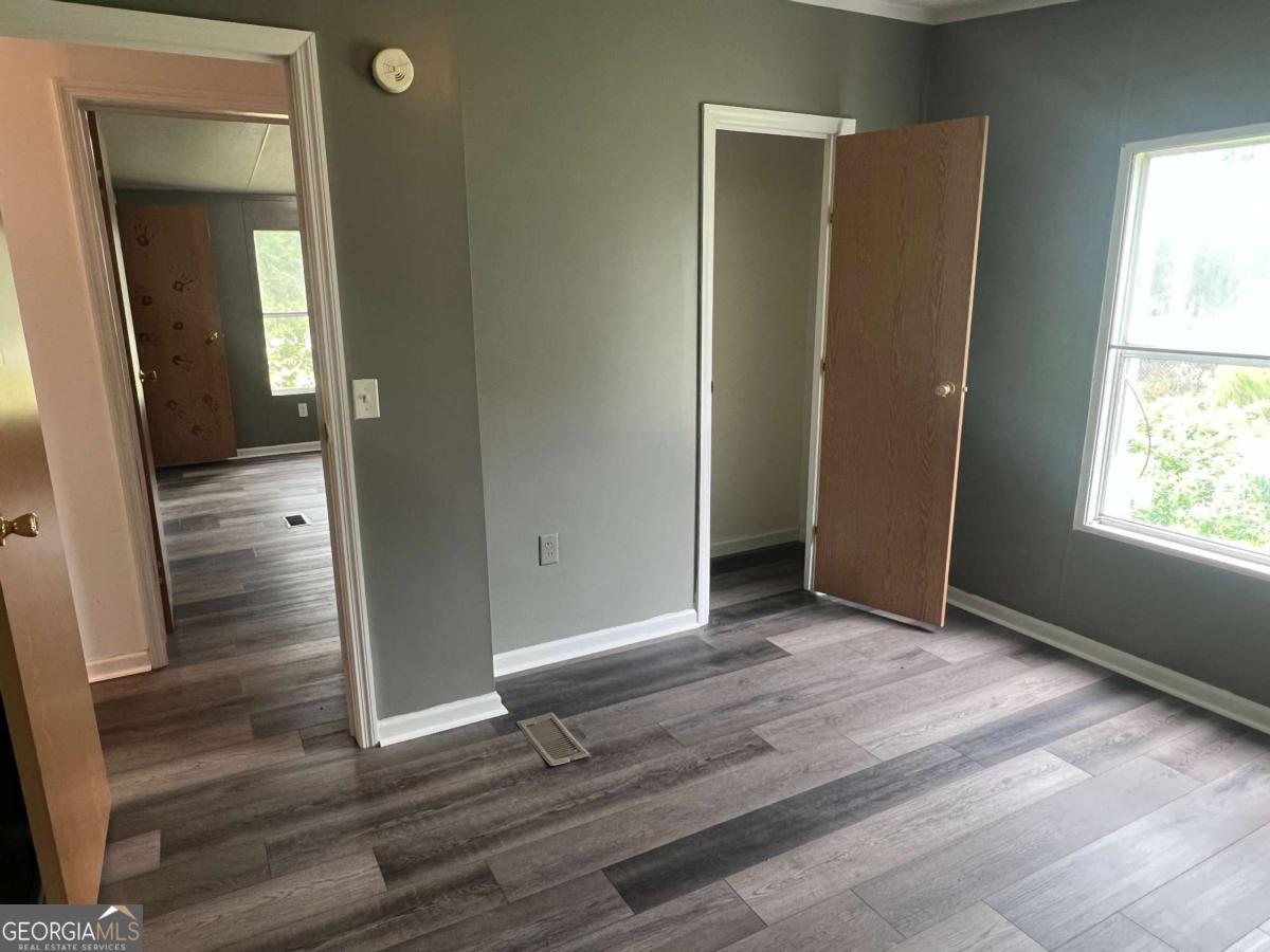 300 Josephine Park Road Waycross, GA 31503 - Photo 12 of 19 an empty room with wooden floor and entrance