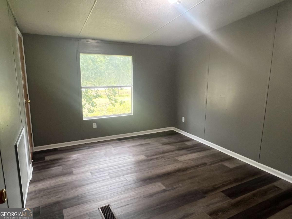 300 Josephine Park Road Waycross, GA 31503 - Photo 13 of 19 an empty room with wooden floor and windows
