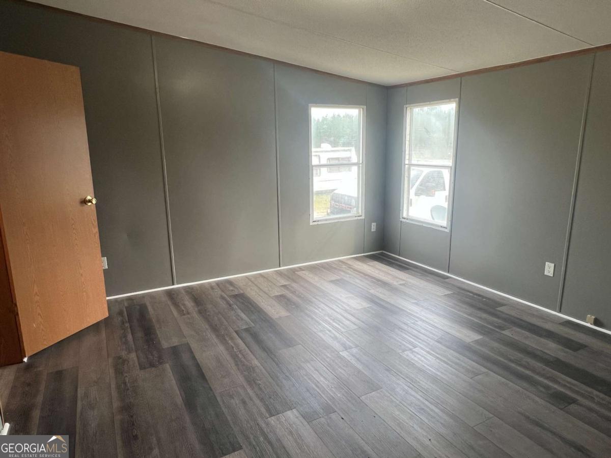 300 Josephine Park Road Waycross, GA 31503 - Photo 15 of 19 an empty room with wooden floor and windows