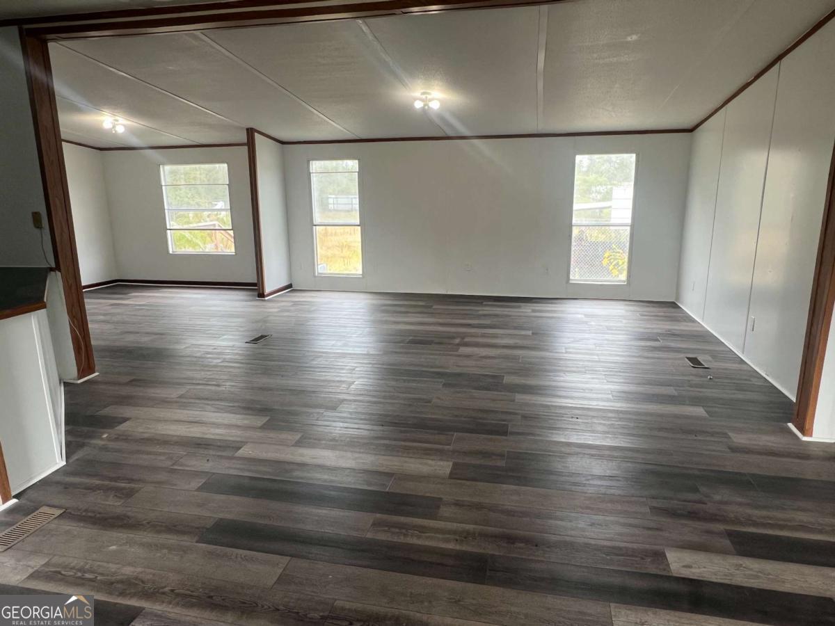 300 Josephine Park Road Waycross, GA 31503 - Photo 3 of 19 an empty room with wooden floor and windows