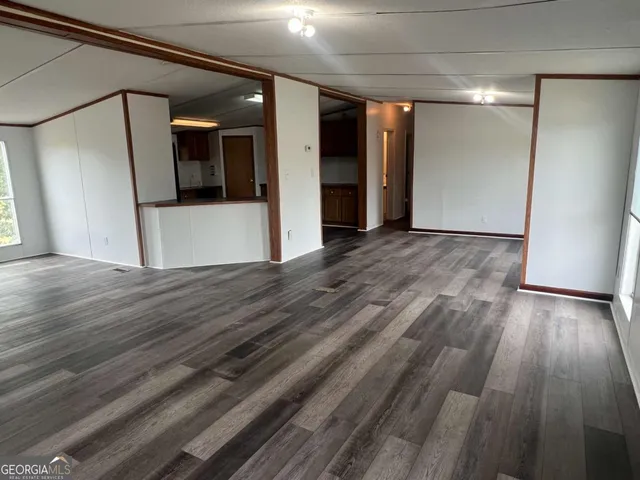 a view of a kitchen with wooden floor and a refrigerator