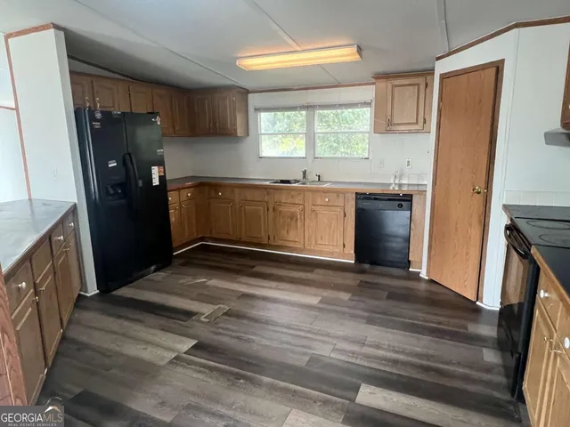 a kitchen with granite countertop a refrigerator and a sink