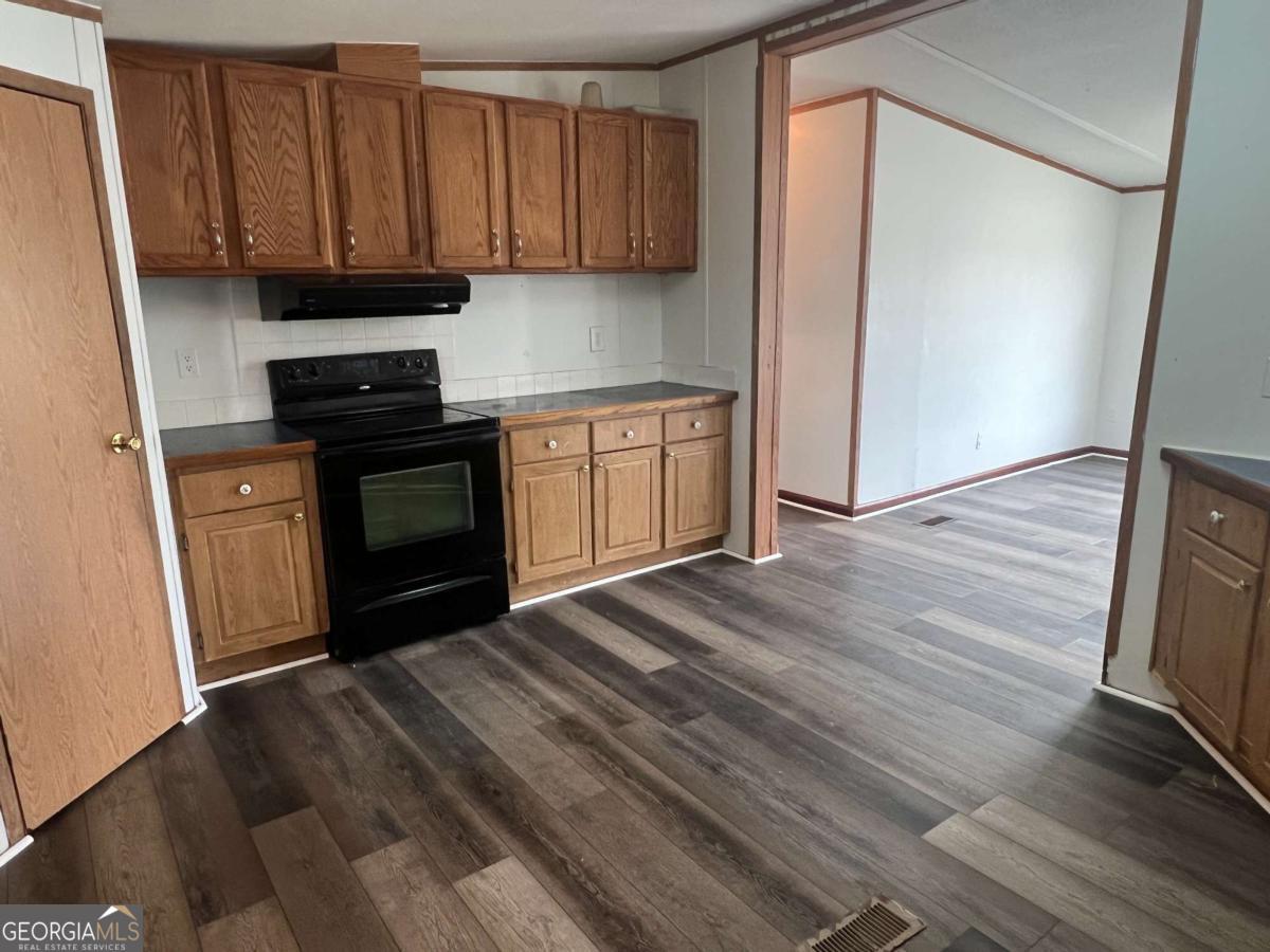 300 Josephine Park Road Waycross, GA 31503 - Photo 7 of 19 a kitchen with a refrigerator stove and wooden cabinets