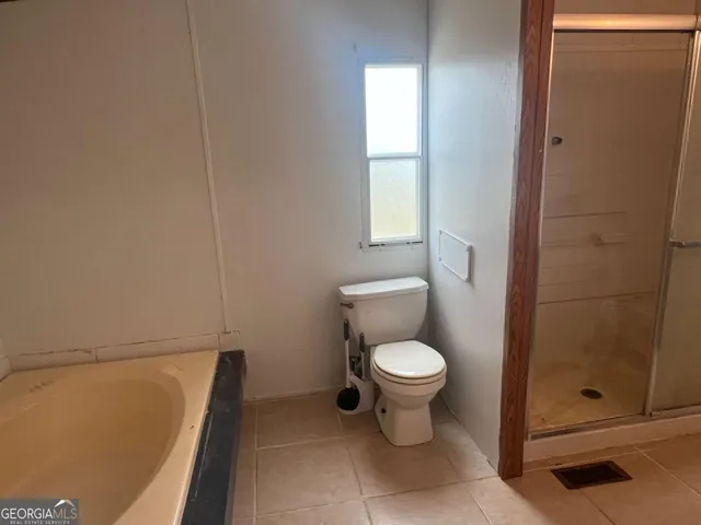 a bathroom with a toilet and a shower