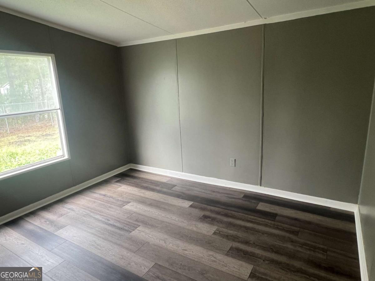 300 Josephine Park Road Waycross, GA 31503 - Photo 10 of 19 an empty room with wooden floor and windows