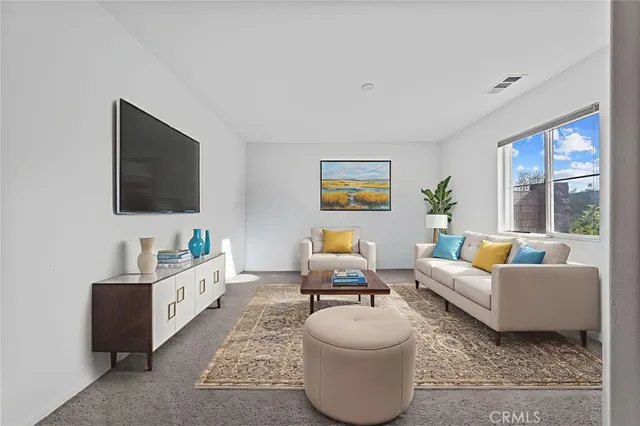 a living room with furniture a flat screen tv and a window