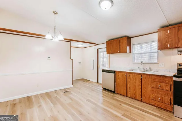 a kitchen with a sink cabinets and wooden floor