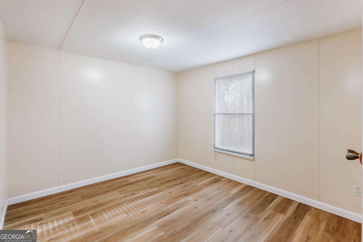 72 Frank Mathews Road Lexington, GA 30648 - Photo 20 of 36 an empty room with wooden floor and windows