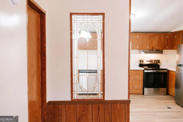 a kitchen with a refrigerator and a stove top oven