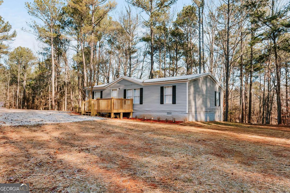 72 Frank Mathews Road Lexington, GA 30648 - Photo 4 of 36 a front view of a house with a big yard and large trees