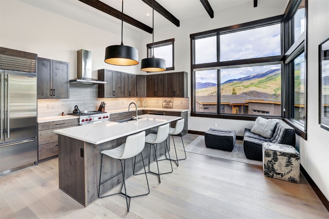 160 Vendette Road Silverthorne, CO 80498 - Photo 16 of 50 Kitchen featuring an island with sink, beamed ceiling, a breakfast bar, built in fridge, and hanging light fixtures