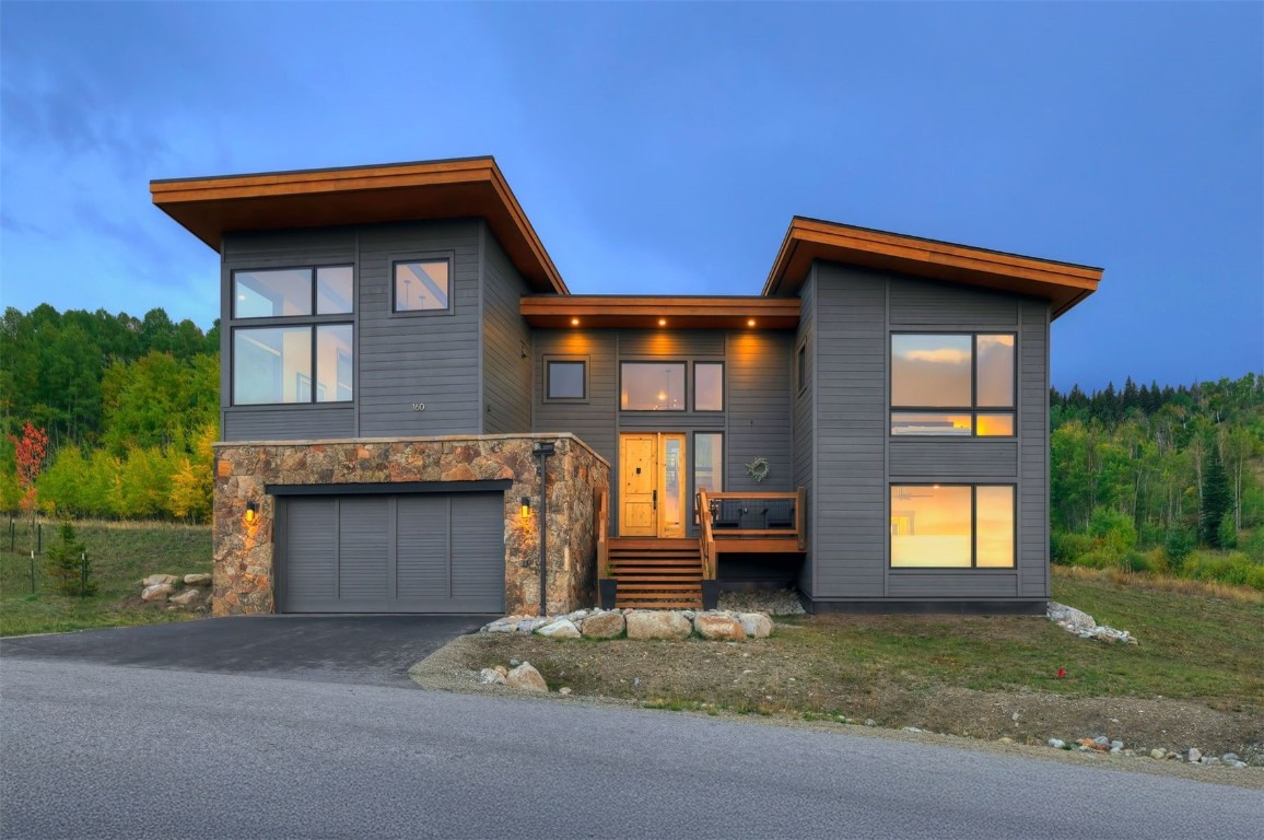 160 Vendette Road Silverthorne, CO 80498 - Photo 3 of 50 Modern home with driveway, a deck, an attached garage, and stone siding