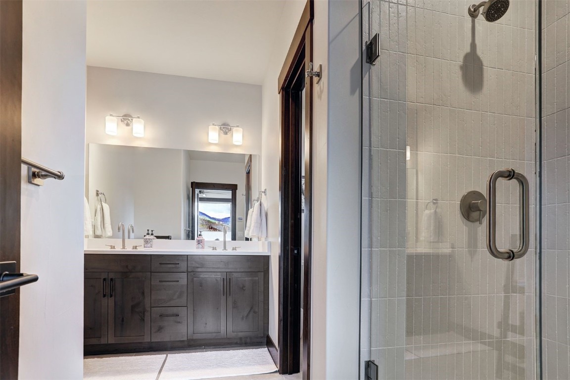 160 Vendette Road Silverthorne, CO 80498 - Photo 31 of 50 Bathroom with a stall shower, double vanity, and light tile patterned floors