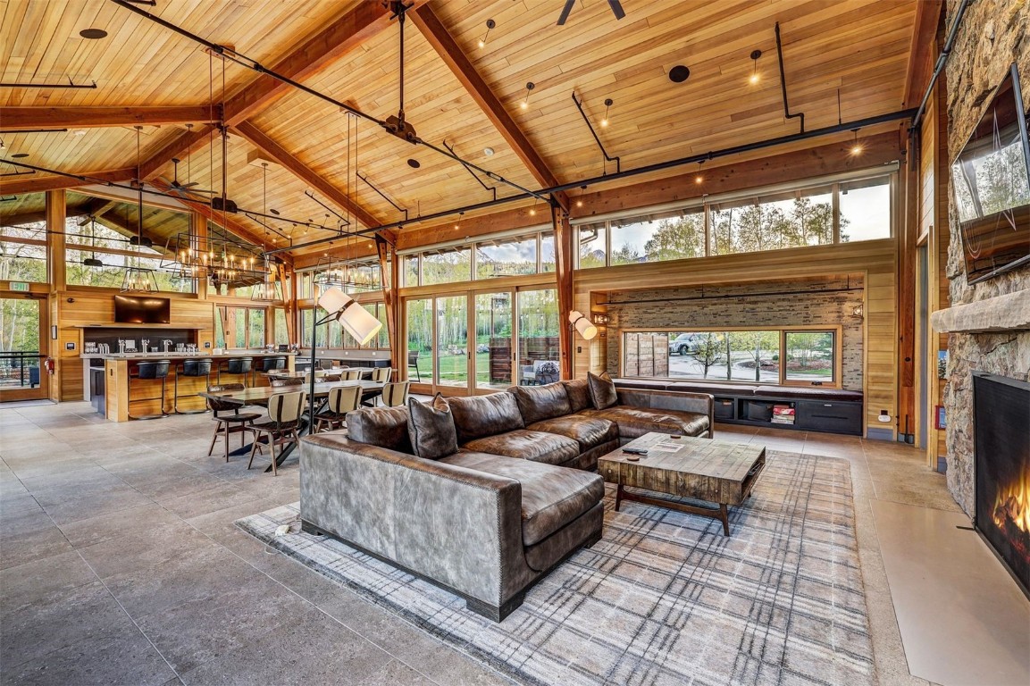 160 Vendette Road Silverthorne, CO 80498 - Photo 42 of 50 Living area with high vaulted ceiling, a wooden ceiling with exposed beams, wood walls, and a fireplace