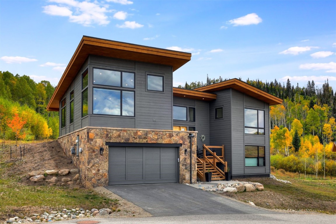 160 Vendette Road Silverthorne, CO 80498 - Photo 5 of 50 Contemporary house with driveway, stairway, stone siding, and a garage