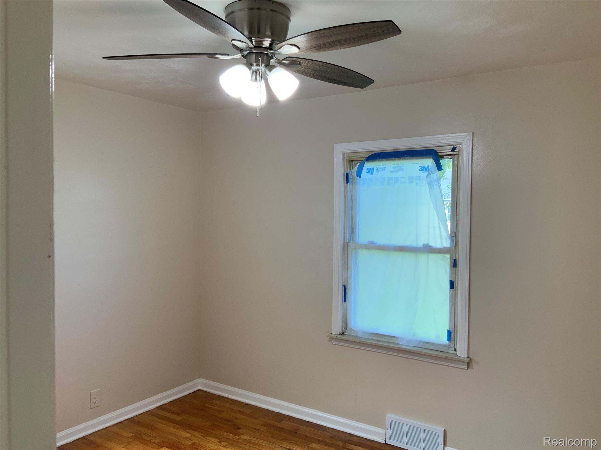 4034 Fleming Road Flint, MI 48504 - Photo 14 of 20 Wood-finish flooring with neutral wall tones and a ceiling fan with integrated lighting