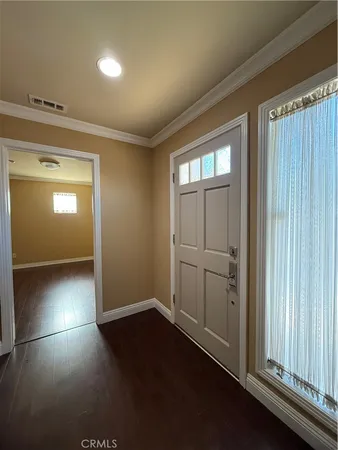 an empty room with wooden floor and window