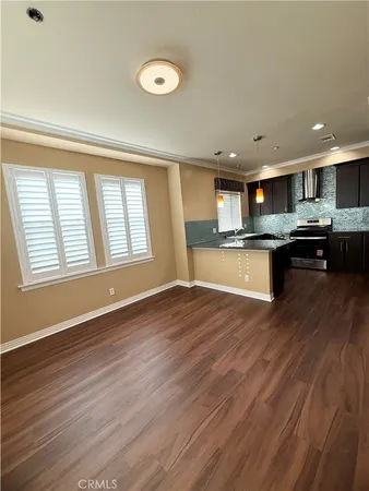 a kitchen with stainless steel appliances granite countertop a sink a stove and a wooden floors