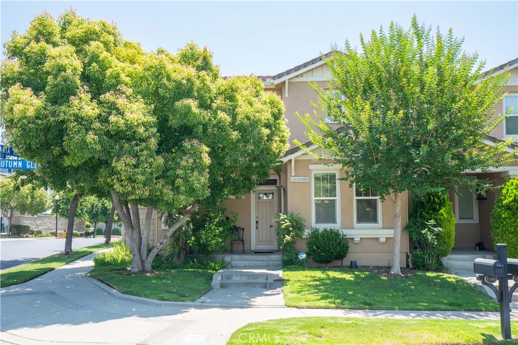 a view of a house with a big yard plants and large trees