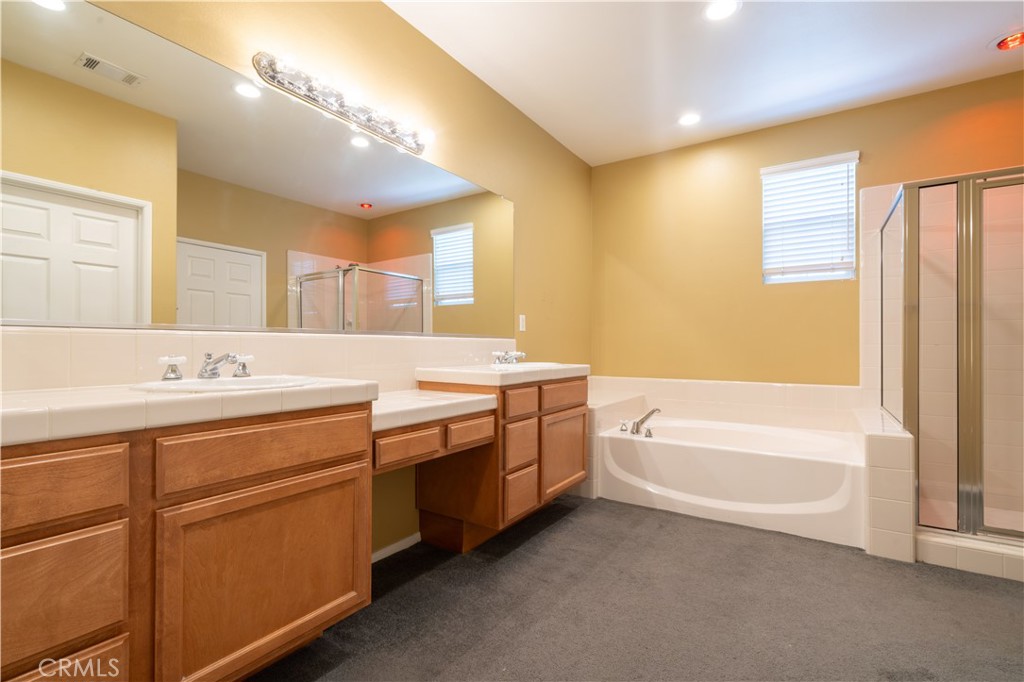 11480 Autumn Glen Court Porter Ranch, CA 91326 - Photo 15 of 38 a spacious bathroom with a double vanity sink a mirror and a bathtub