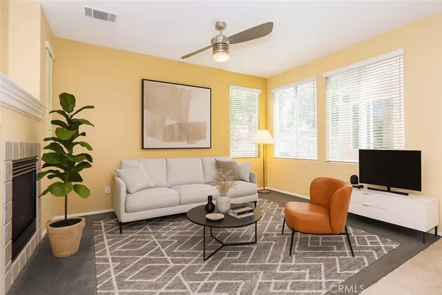 a living room with furniture a flat screen tv and a window