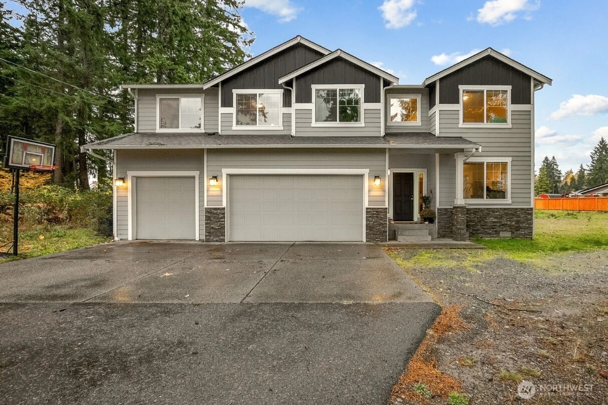 12016 264th Street East Graham, WA 98338 - Photo 2 of 40 a front view of a house with a yard and garage
