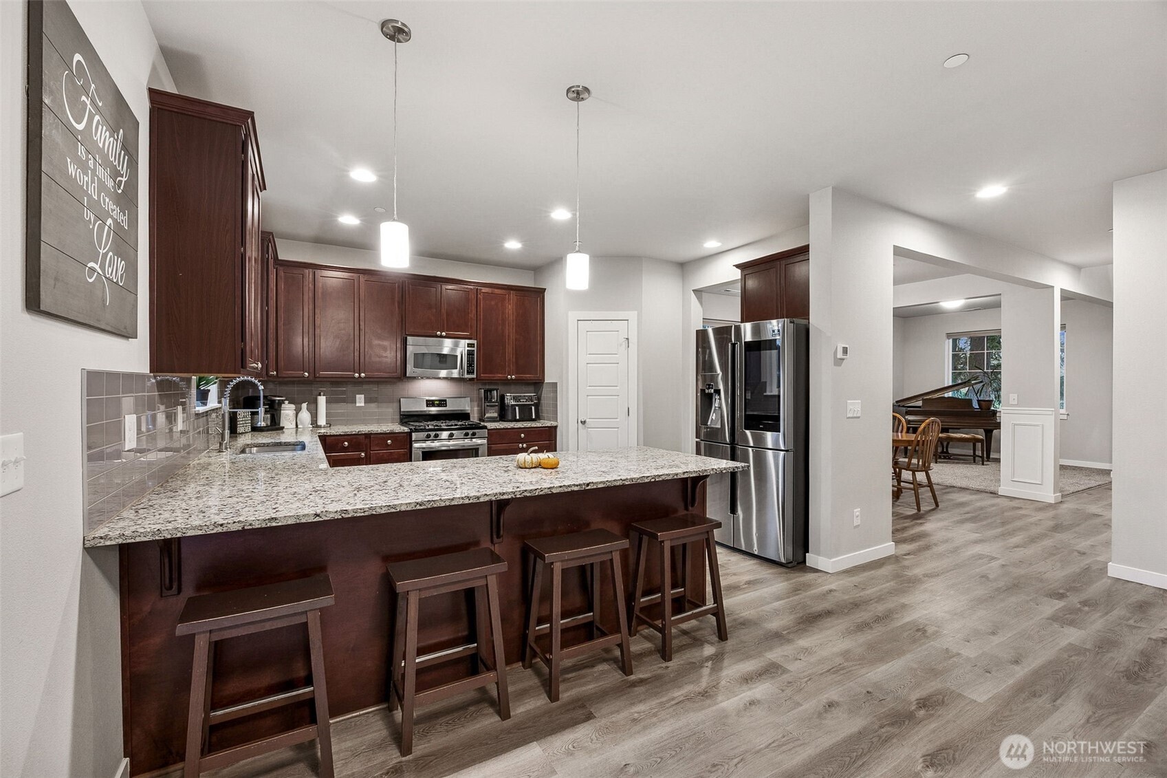 12016 264th Street East Graham, WA 98338 - Photo 9 of 40 a kitchen with stainless steel appliances granite countertop a sink a stove a refrigerator cabinets and chairs