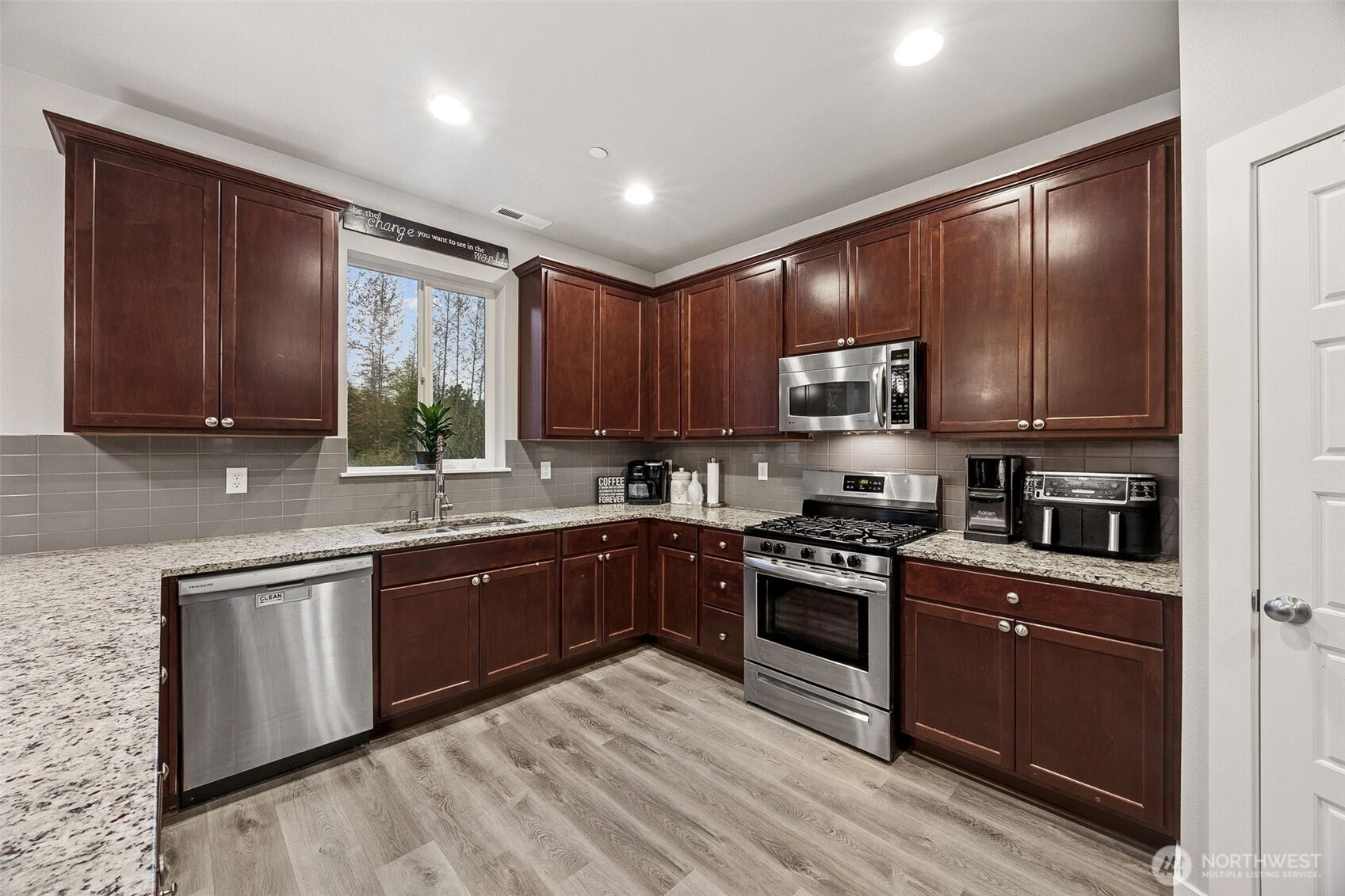 12016 264th Street East Graham, WA 98338 - Photo 10 of 40 a kitchen with stainless steel appliances granite countertop wooden cabinets a sink and a stove