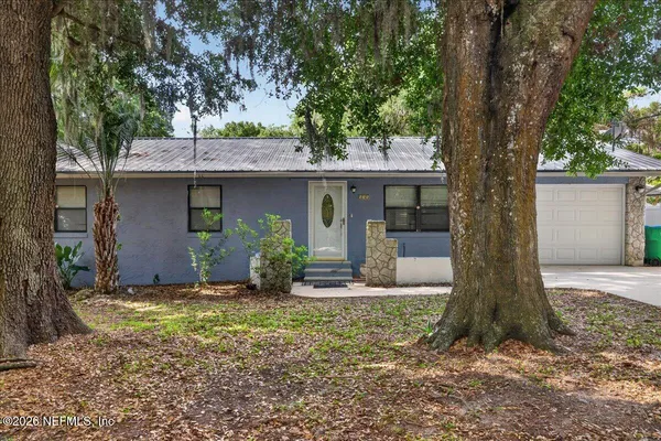 a front view of house with yard and trees around