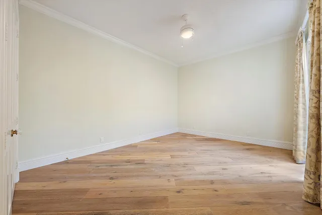 a view of a hallway with wooden floor and stairs