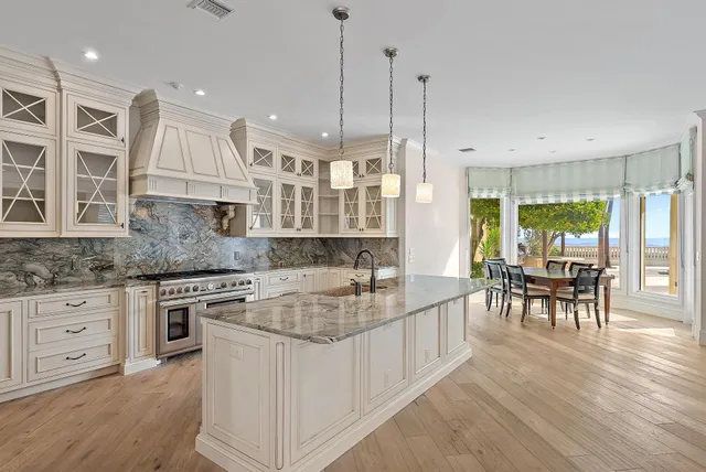 a kitchen with stainless steel appliances granite countertop a sink a stove and a refrigerator