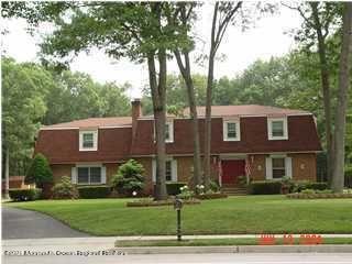 a view of a big yard in front of a brick house