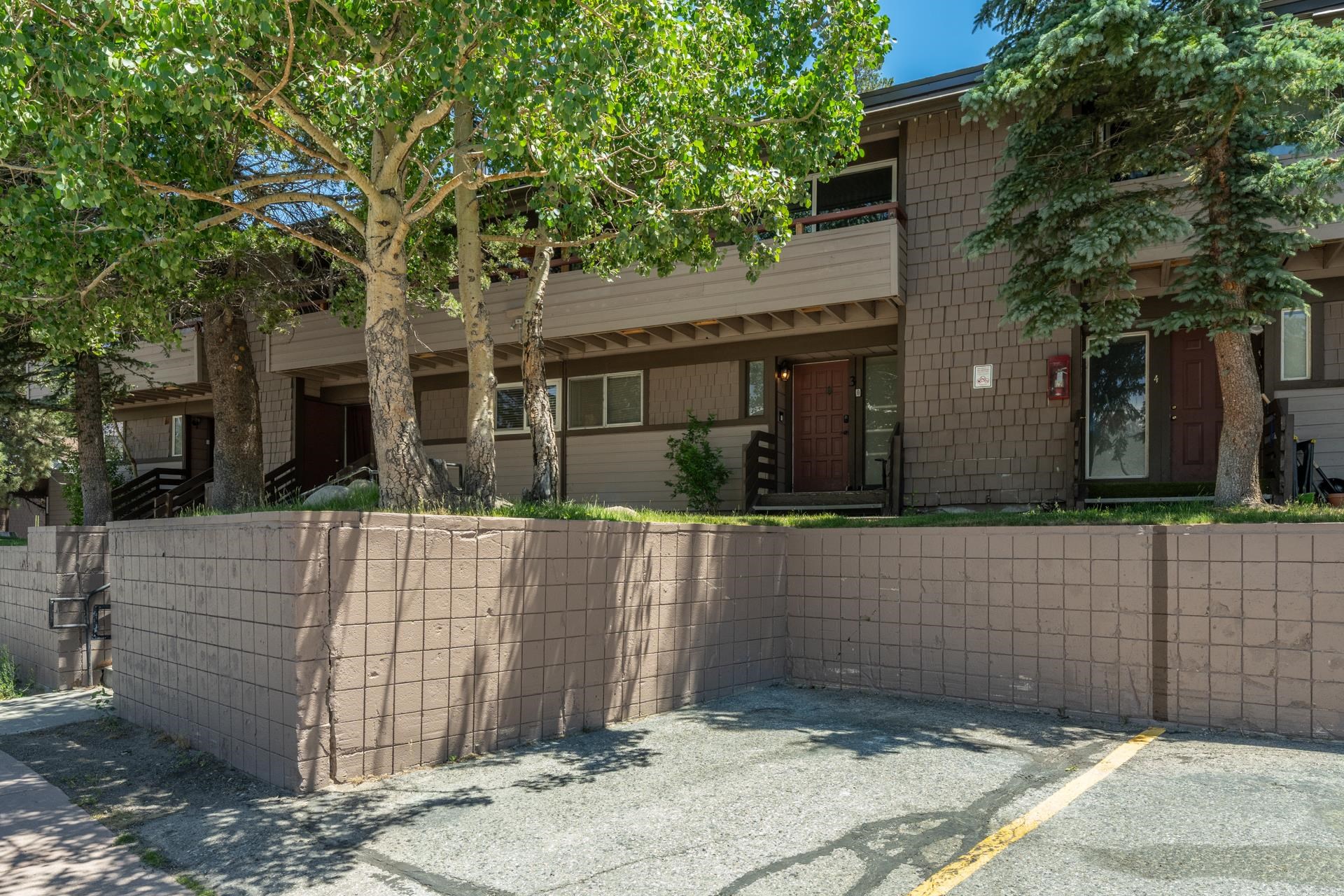 165 Old Mammoth Road, Unit 3 Mammoth Lakes, CA 93546 - Photo 43 of 48 Multi-level residential building featuring wood shake siding and a stone retaining wall