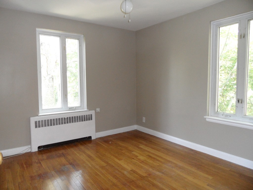 128 Beaconsfield Road, Unit 5 Brookline, MA 02445 - Photo 12 of 18 an empty room with wooden floor and windows