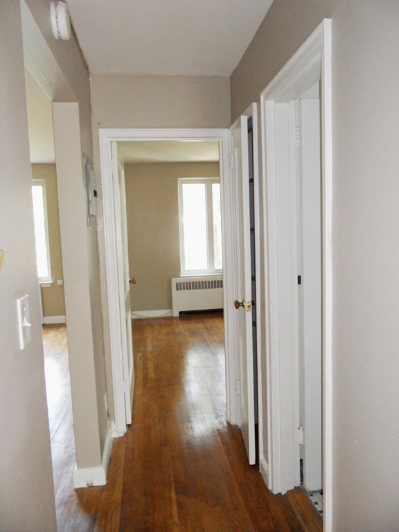 128 Beaconsfield Road, Unit 5 Brookline, MA 02445 - Photo 13 of 18 a view of a hallway with wooden floor and closet