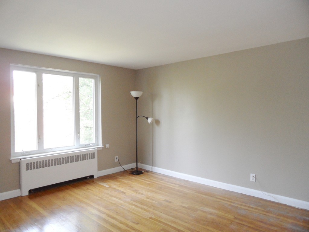128 Beaconsfield Road, Unit 5 Brookline, MA 02445 - Photo 2 of 18 an empty room with wooden floor and windows