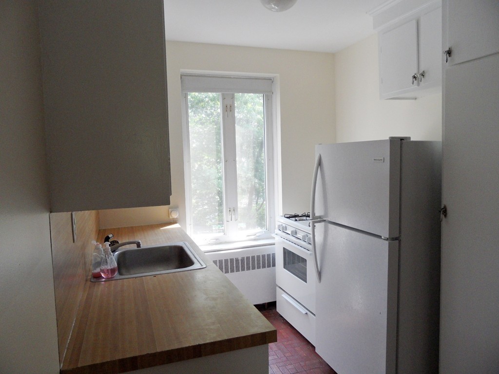 128 Beaconsfield Road, Unit 5 Brookline, MA 02445 - Photo 6 of 18 a kitchen with stainless steel appliances a refrigerator and a window