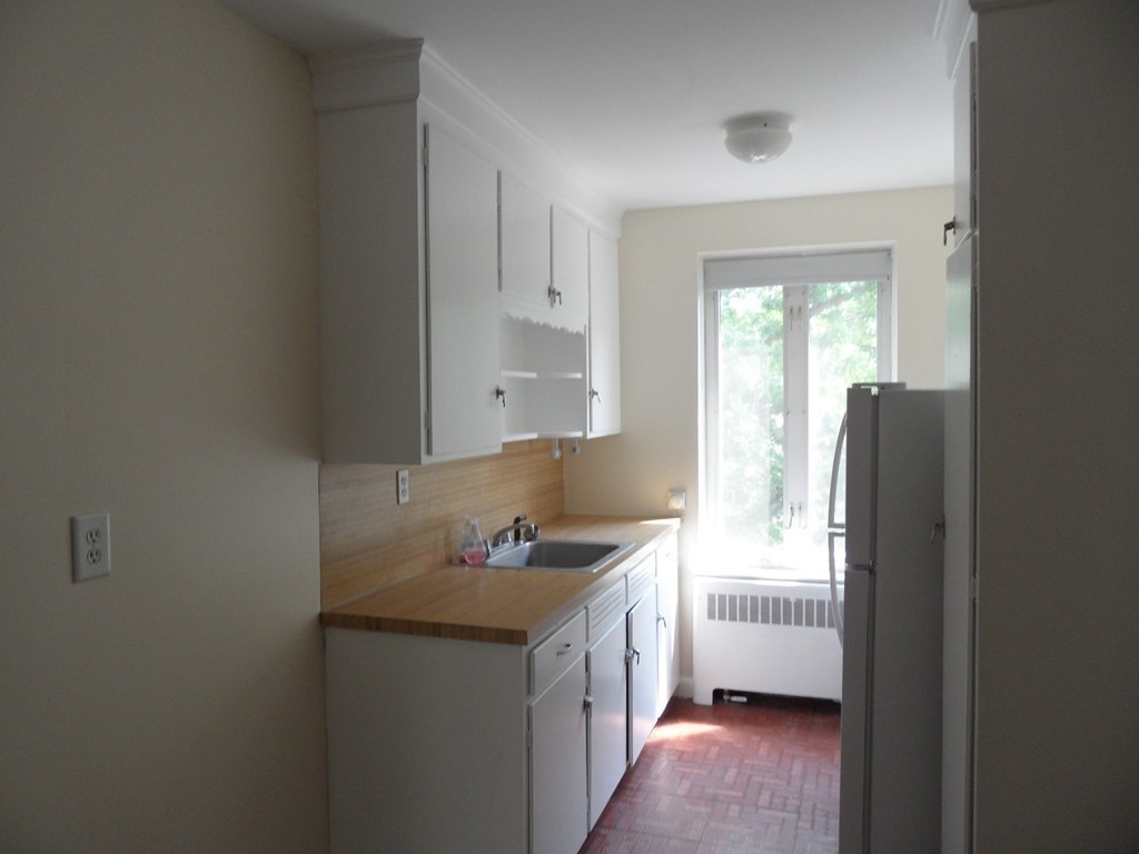 128 Beaconsfield Road, Unit 5 Brookline, MA 02445 - Photo 7 of 18 a kitchen with a sink cabinets and a window