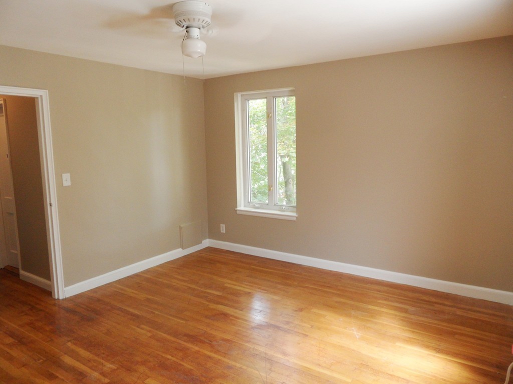 128 Beaconsfield Road, Unit 5 Brookline, MA 02445 - Photo 9 of 18 a view of an empty room with wooden floor and a window