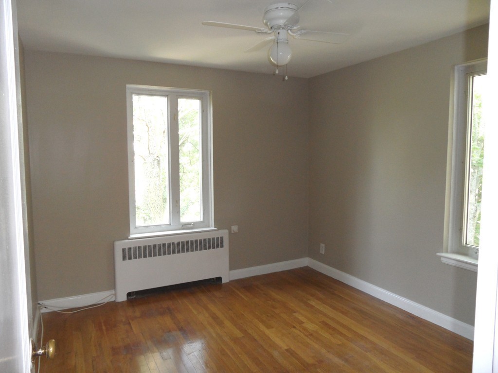 128 Beaconsfield Road, Unit 5 Brookline, MA 02445 - Photo 10 of 18 wooden floor in an empty room with a window