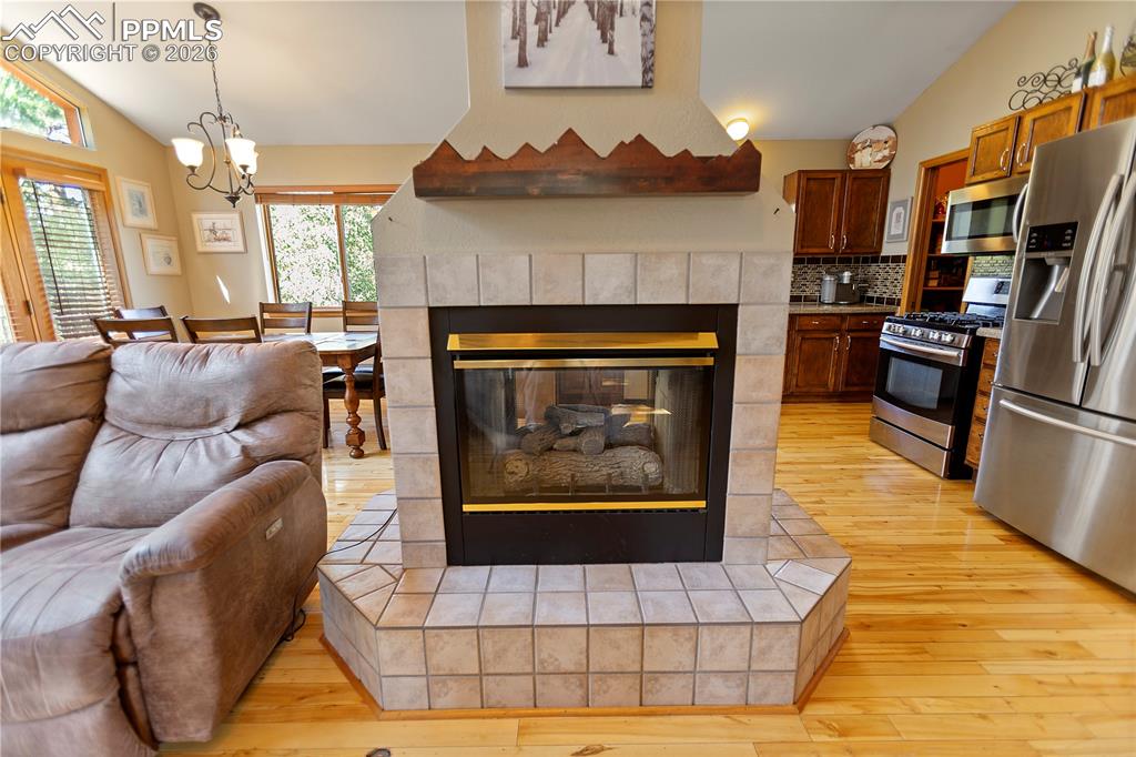 566 Spring Valley Drive Divide, CO 80814 - Photo 5 of 30 a living room with furniture a fireplace and a chandelier